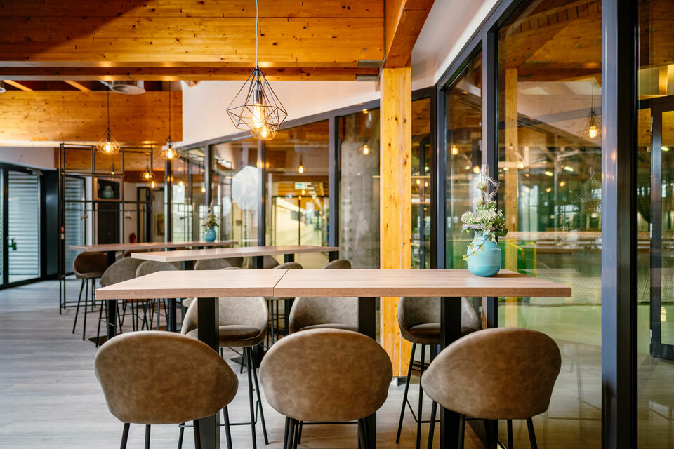 Ein Sitzplatzbereich des Ahorn-Squash Bistros mit einem hohen Tisch und sechs hohen Sitzplätze