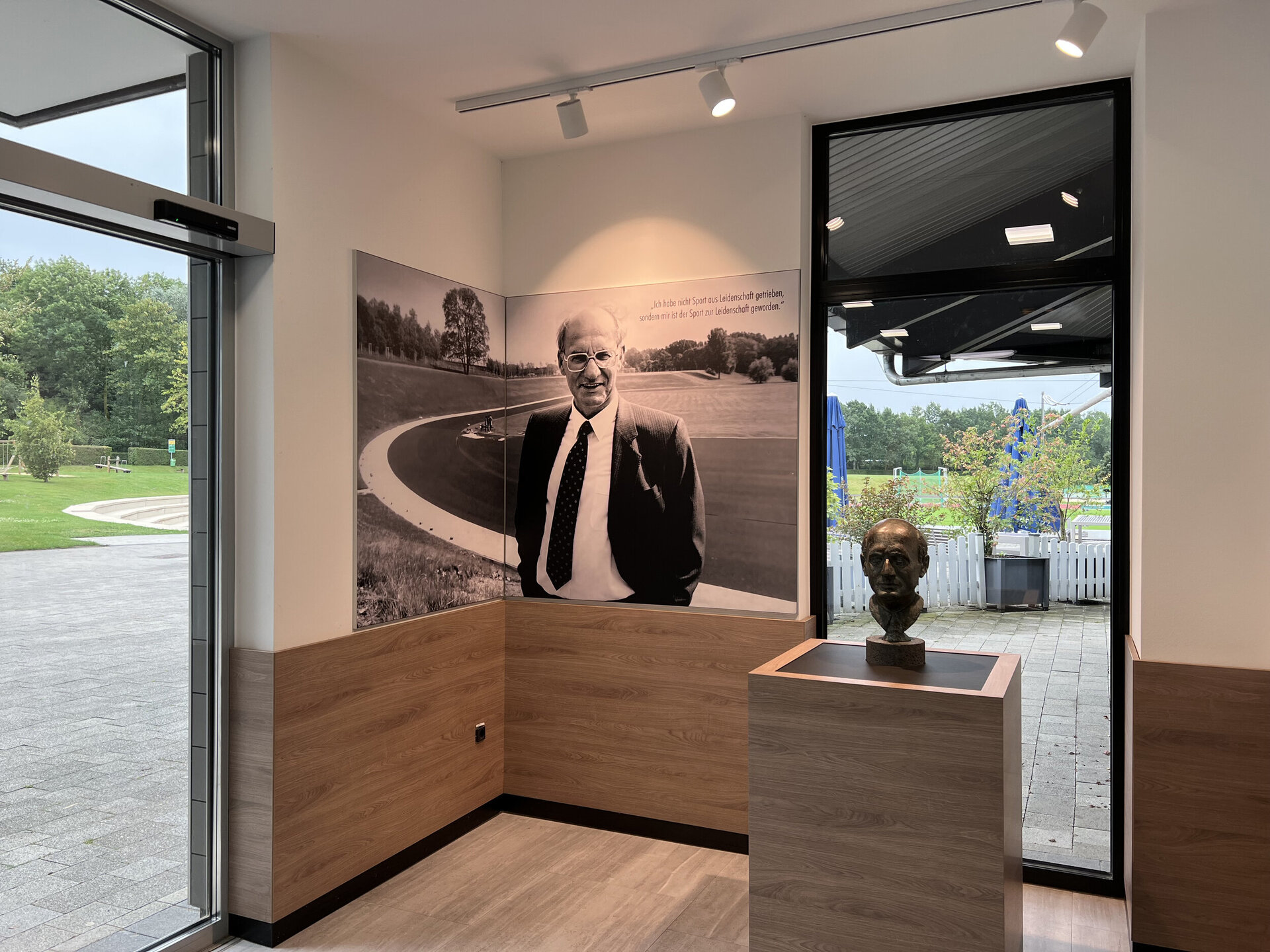 Im Eingangsbereich der Ahorn-Sportpark-Halle ist eine Büste mit dem Kopf von Heinz Nixdorf abgebildet. Im Hintergrund an der weißen Wand hängt zwischen der Eingangstür und einem bodentiefen Fenster ein Foto auf einer Leinwand von Hienz Nixdorf. Auf diesem schwaz-weiß Foto steht er vor dem Leichtathletikstadion mit Blick nach vorne. Am oberen Rand des Bildes ist folgendes Zitat von Heinz Nixdorf niedergeschrieben: "Ich habe nicht Sport nicht aus Leidenschaft getrieben, sondern mir ist der Sport zur Leidenschaft geworden."