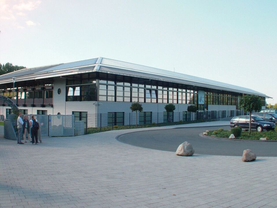 Das Foto zeigt die neue Hallenostseite des Ahorn-Sportparks. Im Vordergrund ist der Bürgersteich mit wartenden Personen vor dem Zutritt zum Ahorn-Sportpark-Gelände zu sehen.