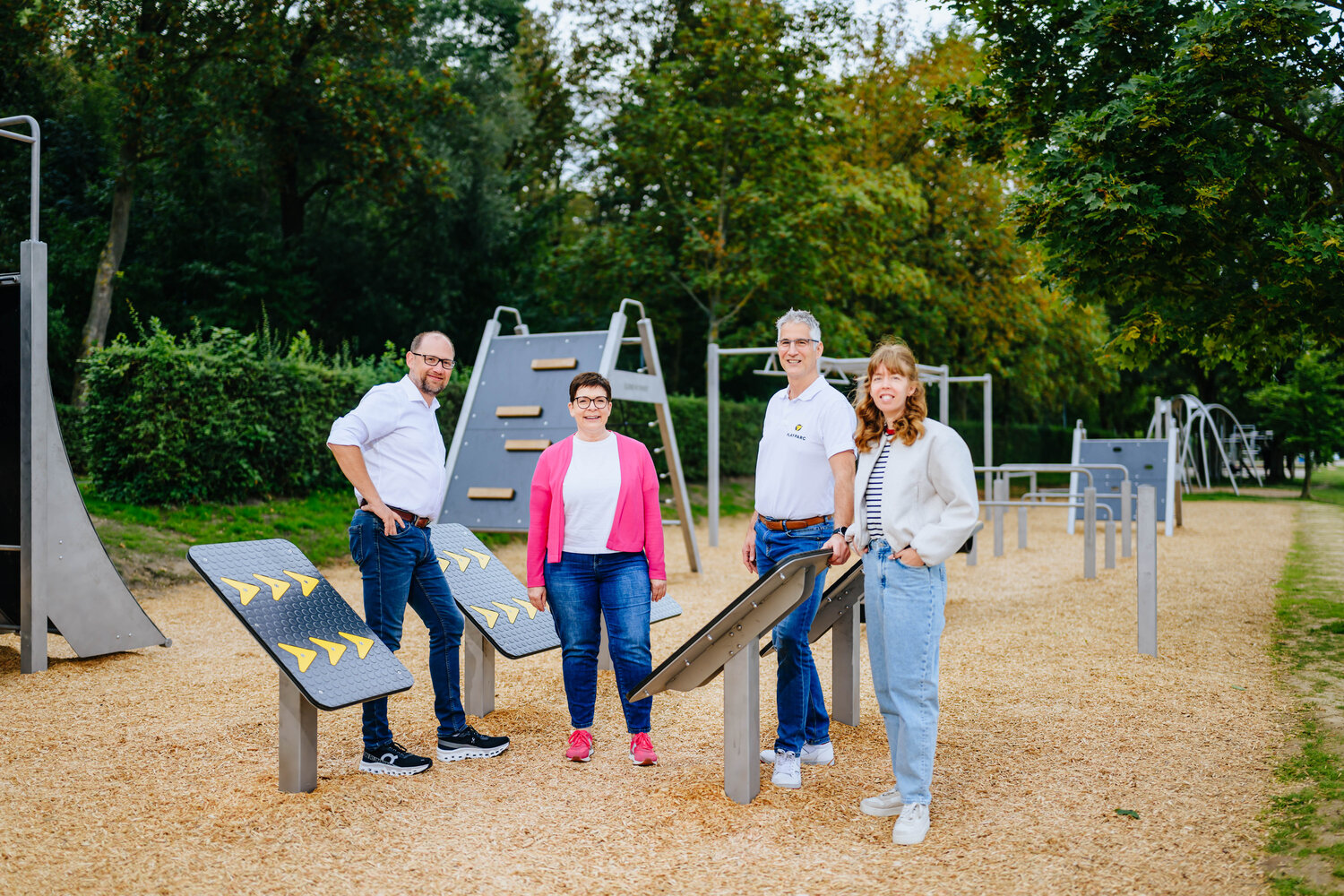 Vier Personen stehen an einen Bewegungselement des neuen Hindernis-Parcours im Ahorn-Sportpark. Im Hintergrund sind weitere Elemente des Parcours zu erkennen.